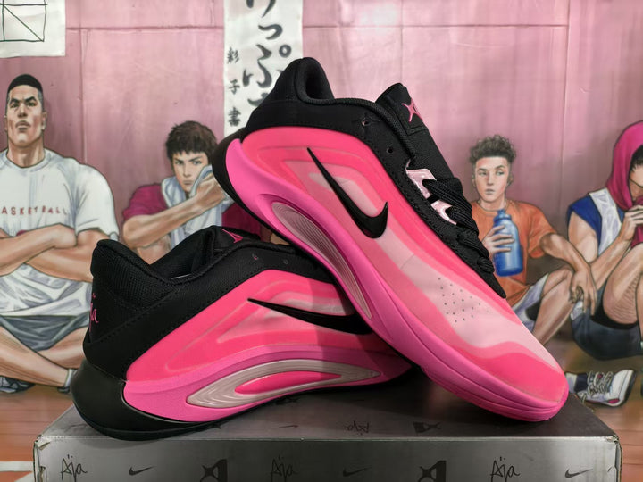 Pair of black and vivid pink sneakers shown from a three-quarter side angle on a shoebox.