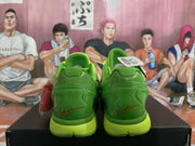 Rear view of the green Nike sneakers showing layered heel construction, lime-colored midsoles, and red heel graphics.