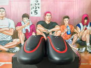 Front view of black clogs with red trim and small marks on the uppers.