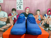Front view of blue Nike basketball sneakers with orange tongue logos and blue laces.