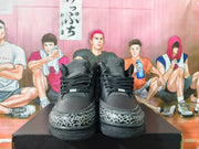 Front view of black Jordan sneakers showing black laces and gray elephant-print toe overlays