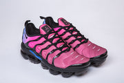 Pair of pink and black Nike sneakers with blue heel accents.