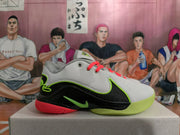 Side view of a grey and black Nike basketball shoe with lime green and coral accents