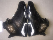 Overhead view of the paired sneakers showing the black upper, white midsole accents, and side-panel perforations.