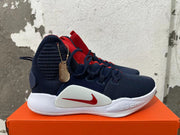 Side view of a navy Nike Zoom basketball shoe with red Swoosh and white midsole