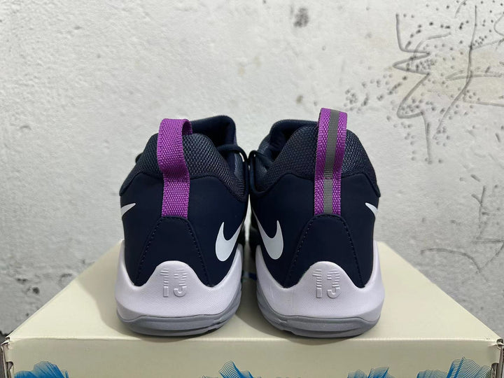 Rear view of navy and white Nike PG 1 basketball shoes with purple heel pull tabs