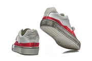 Red and gray low-top sneakers shown from the heel and outsole
