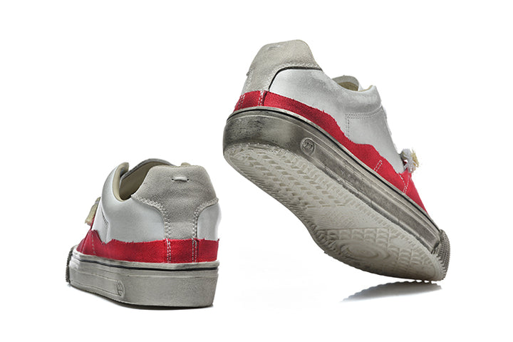 Red and gray low-top sneakers shown from the heel and outsole