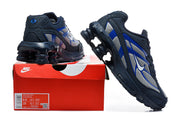 Nike Shox Ride 2 sneakers in navy, silver-gray, and blue displayed with a shoebox; the box label shows a sample size.