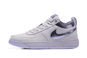Side profile of a purple Nike sneaker showing the layered upper, side logo and flat sole.