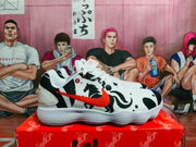 Side profile of a white Nike sneaker with black zebra-inspired graphics, a red Swoosh, red eyelets, and a layered white outsole.