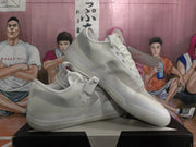 Angled view of a pair of white sneakers displaying the mesh-style texture, lace-up construction, and layered sole.