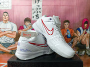 Angled view of the white shoes showing red Swoosh details, laces, and heel graphics.