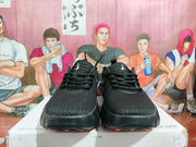 Front view of black Nike sneakers showing the rounded toe boxes, black laces, and textured uppers.