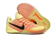 Yellow and orange Nike low-top basketball shoes with a black Swoosh and translucent outsole.