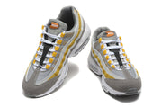 Front and top views of grey, white and yellow Nike Air Max 95 TT sneakers.