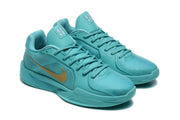 Pair of aqua basketball shoes with gold-colored Swoosh accents, shown at an angle.