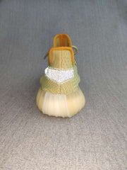 Rear view of a green sneaker showing the reflective heel detail, amber collar, pull tab, and rounded translucent sole.