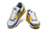 Front angled view of a pair of Nike Air Max 90 sneakers.