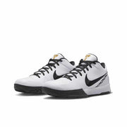 White Nike Kobe 4 basketball sneakers with black Swoosh branding and gold tongue details.