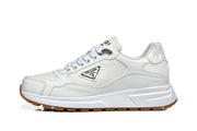 Side view of a white Prada logo sneaker with a chunky white sole and gum-colored tread.