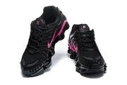 Pair of black and pink Nike Shox TL sneakers shown from front and side