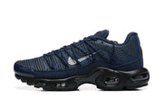 Side profile of a navy Nike Air Max Plus sneaker with silver-tone Swoosh and black sculpted sole.