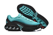 Nike Air Max DN sneakers shown from the side and underside, with turquoise outsole details.