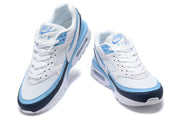 Front and angled views of the white, light blue and navy Nike Air Max sneakers.