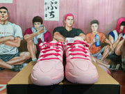 Front view of pink and white Nike basketball sneakers displayed on a shoebox.