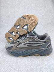 Gray 700 V2-style sneaker shown from the side with the gum-colored outsole visible underneath.
