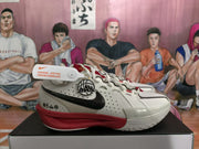 Side view of a white Nike basketball shoe with black Swoosh and red midsole accents