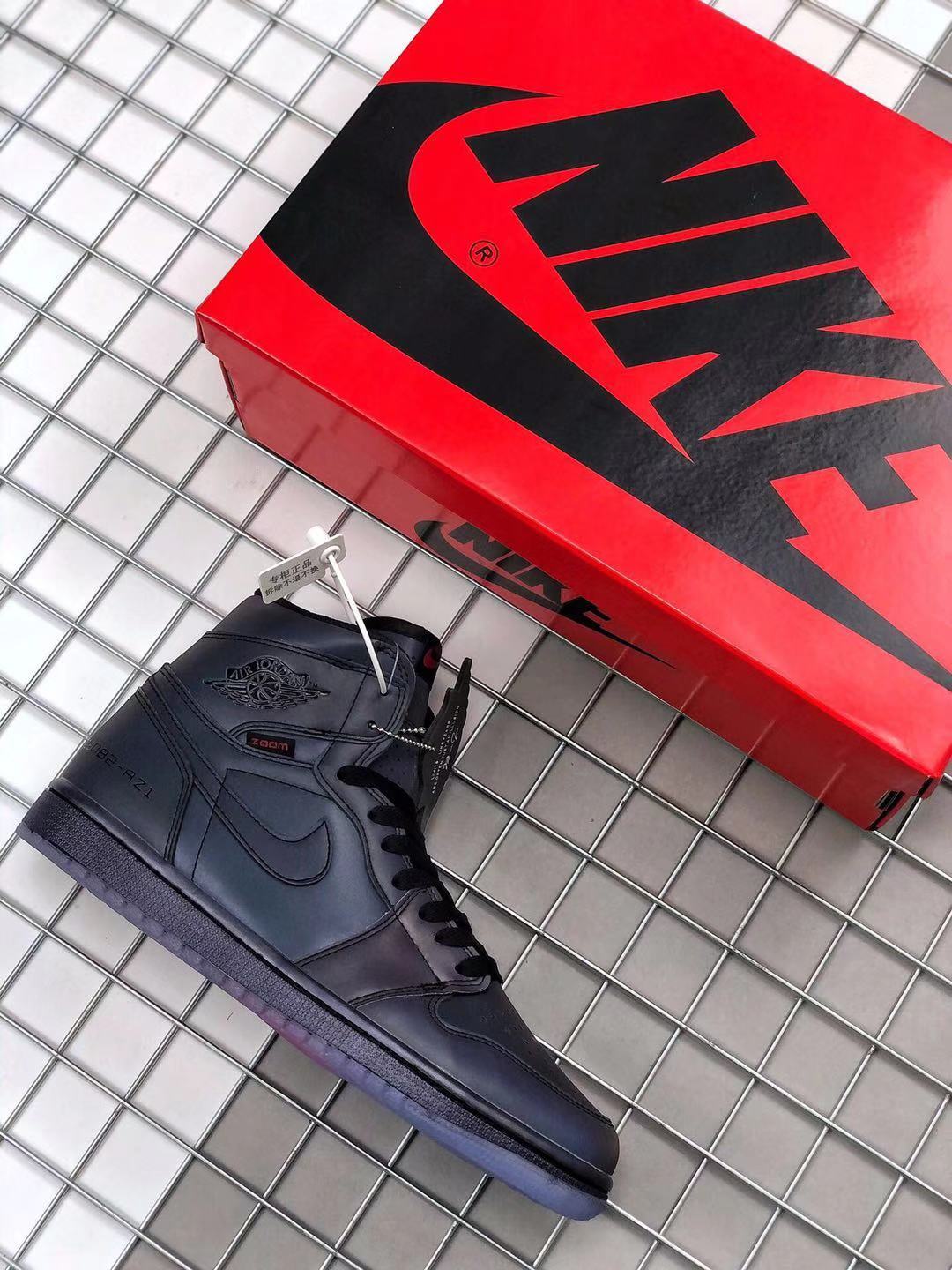Black high-top sneaker displayed beside a red Jordan shoebox.