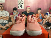 Front view of pink Nike basketball shoes with pink laces, red tongue labels, and white outsoles.