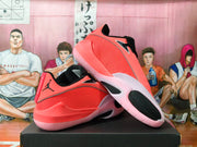 Side view of coral pink Jordan basketball shoes with mesh-textured panels and black details
