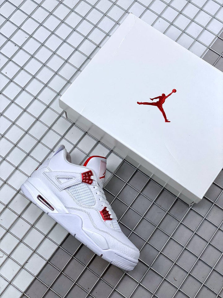 White and red Air Jordan 4 sneaker displayed beside a white shoebox.