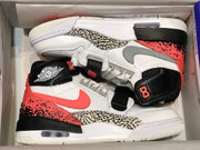 Top-down view of the pair inside the shoe box, showing the high-top construction, straps, patterned panels, and contrasting color blocks.