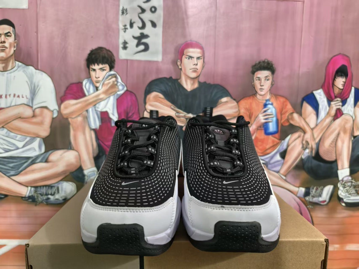 Front view of black, grey, and white Nike sneakers displayed on a box.