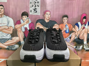 Front view of black, grey, and white Nike sneakers displayed on a box.