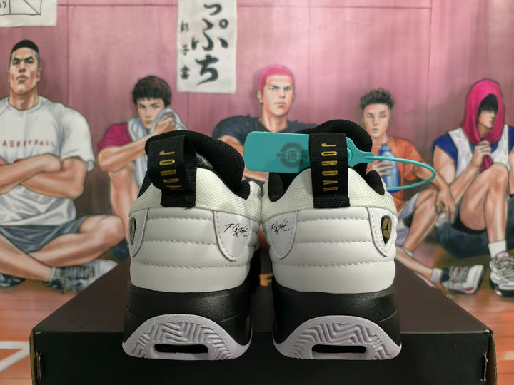 Rear view of white and black Jordan basketball sneakers with gold accents and heel pull tabs