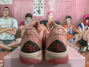 Rear view showing the pink sneakers’ textured heel panels and dark heel accents.
