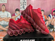 Angled view of paired red Nike Air Max Dn sneakers displaying the side panels, heel structure, and sculpted soles.