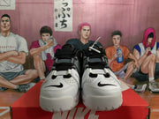 Front view showing the white and grey toe panels, black laces and small black swoosh details.