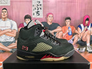 Side view of a black high-top sneaker with a perforated light side panel, red accents, visible number 23, and a contrasting outsole.