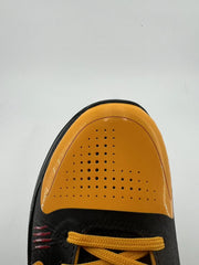 Top-down view of the perforated orange toe and yellow-orange laces.