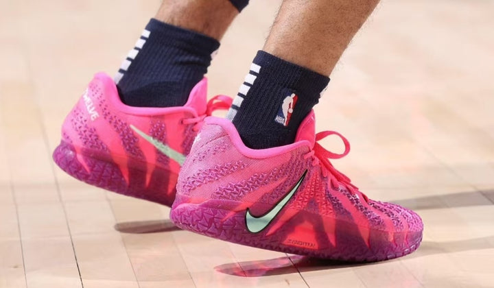 Pair of pink and purple Nike basketball sneakers with visible Swoosh logos, patterned uppers, and translucent textured outsoles.