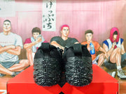 Rear view of black textured sneakers showing heel pull tabs and patterned soles.