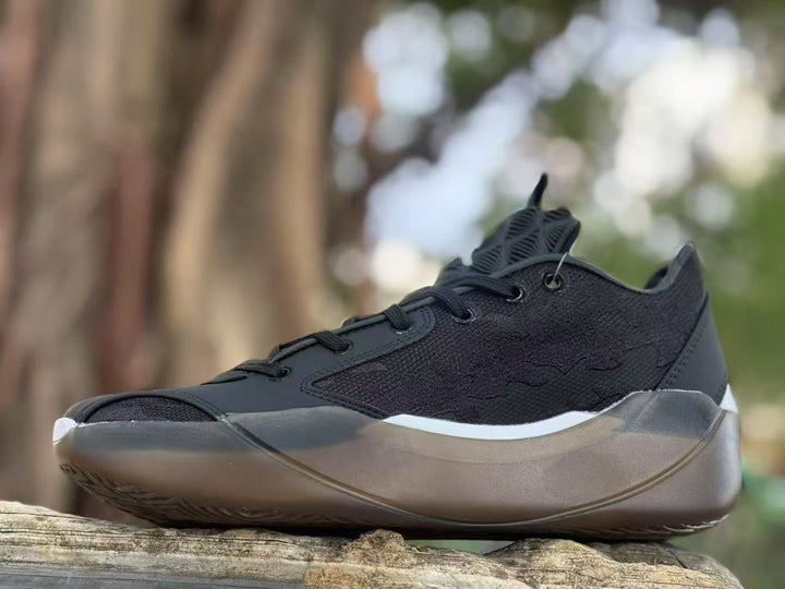 Side view of a black Jordan 39 sneaker showing its textured upper, white side accent, and translucent brown sole.