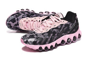 Angled view of black and pink Nike Air Max DN8 sneakers with patterned uppers and pink laces.
