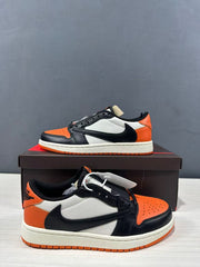 Pair of black, orange and white low-top sneakers shown from side and front angles.